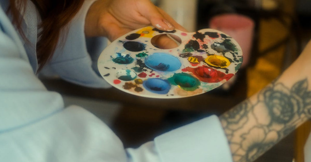 attoo artist mixing colorful inks on a palette to create custom tattoo shades.