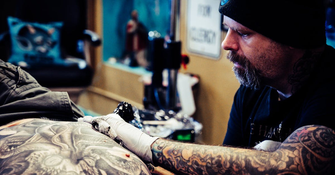 Tattoo artist focused on shading a large tattoo using the Bishop Power Wand machine