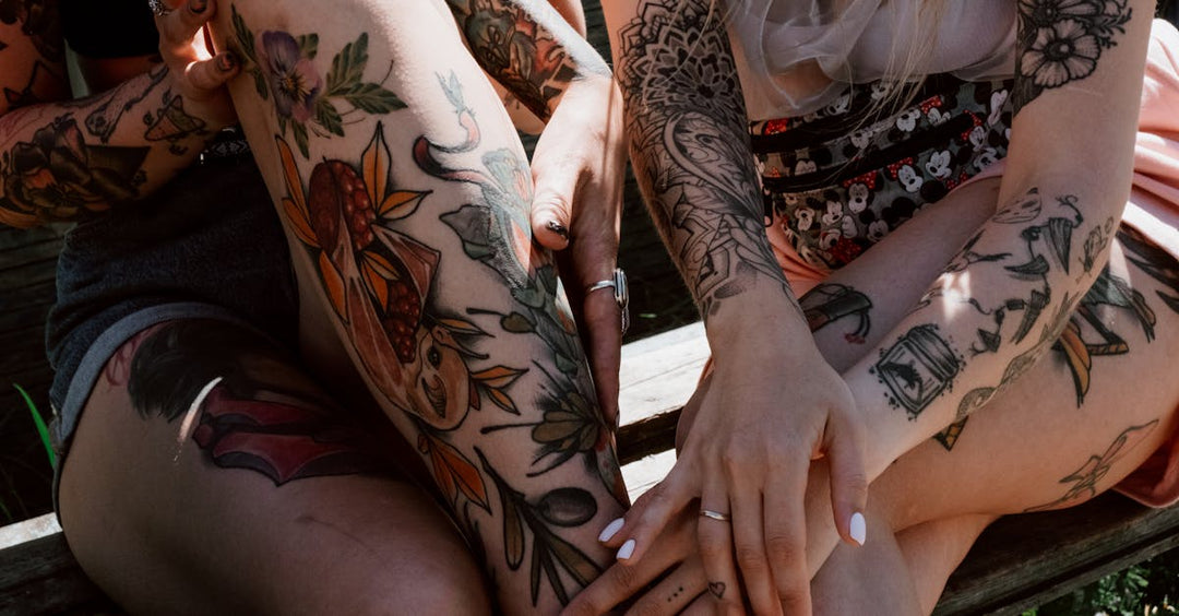 Group of tattooed individuals showcasing vibrant, colorful ink designs on arms and legs