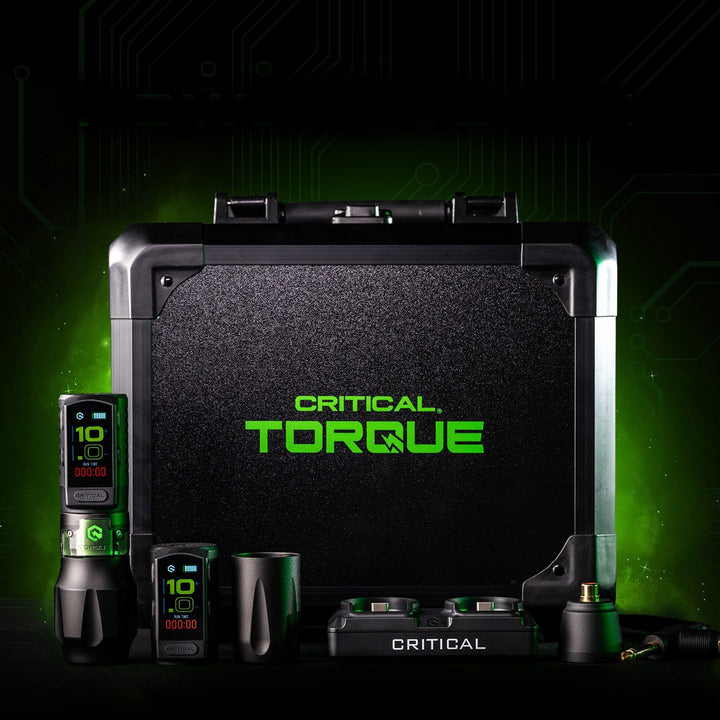 Critical Torque tattoo machine set, featuring the machine, power supply, and accessories with a green and black carrying case.