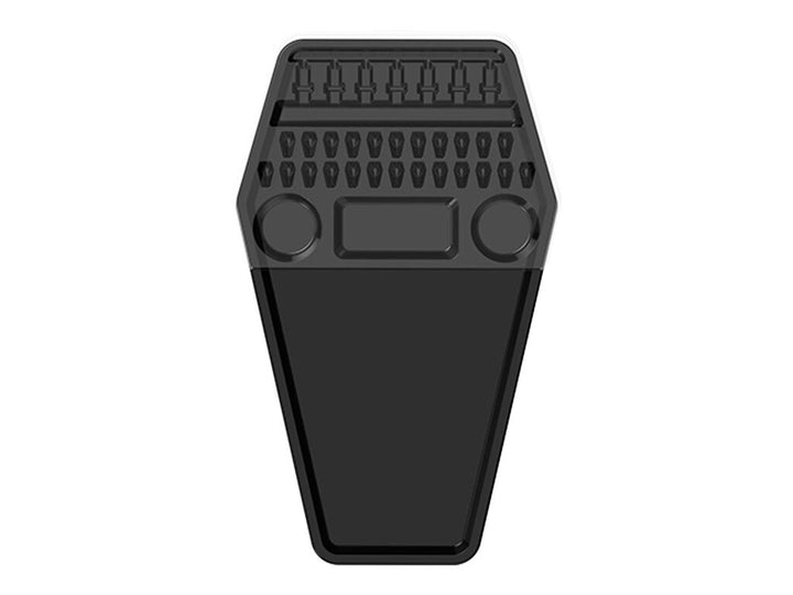 A black coffin-shaped foot pedal with a textured tread pattern and circular cutouts, shown against a plain white background.